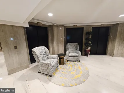 a living room with furniture a flat screen tv and kitchen view