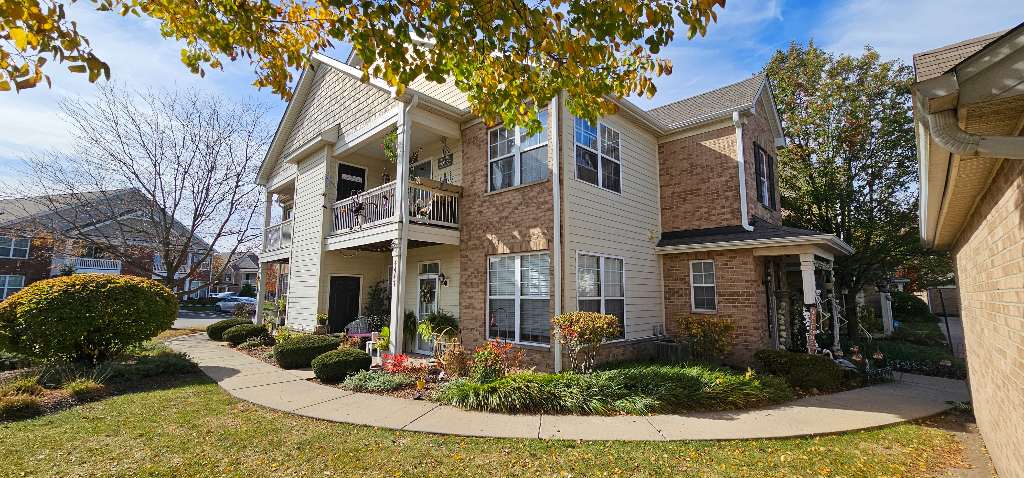 4449 Timber Ridge Court, Unit 105D Joliet, IL 60431 - Photo 2 of 4 a front view of a house with garden
