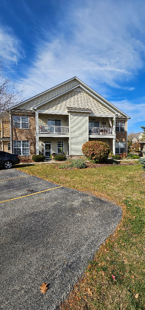 4449 Timber Ridge Court, Unit 105D Joliet, IL 60431 - Photo 4 of 4 a view of a house with a yard