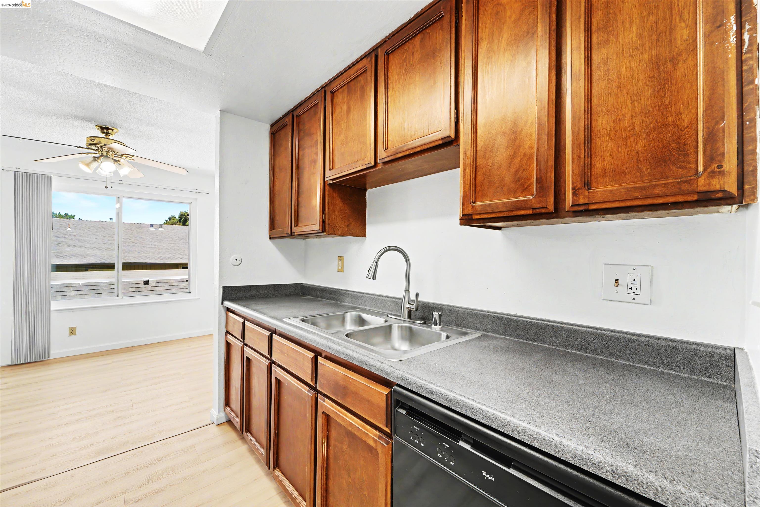 4186 San Pablo Dam Road, Unit A El Sobrante, CA 94803 - Photo 19 of 34 Kitchen area featuring wood cabinetry, a double basin stainless steel sink with a gooseneck faucet, gray countertops, and a black built-in dishwasher