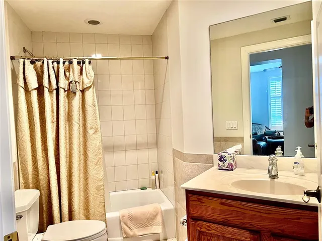 a view of a bedroom with a bed and wooden floor