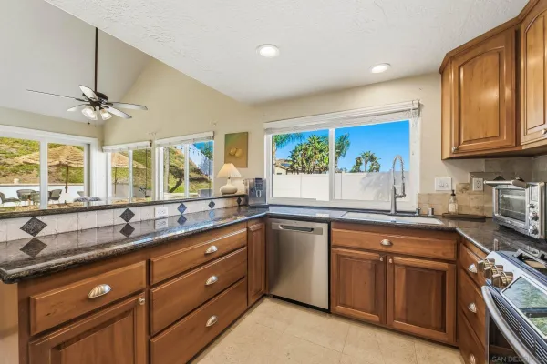 a kitchen with stainless steel appliances granite countertop a refrigerator stove and sink
