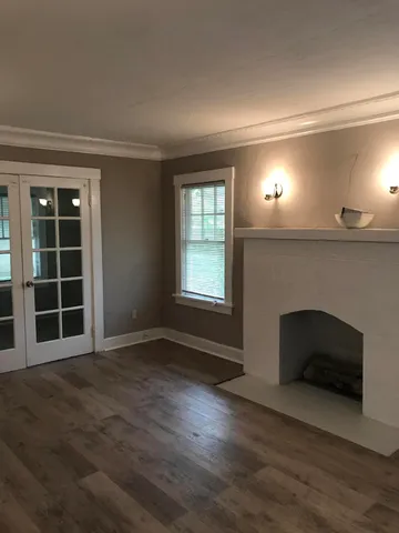 an empty room with wooden floor and fireplace