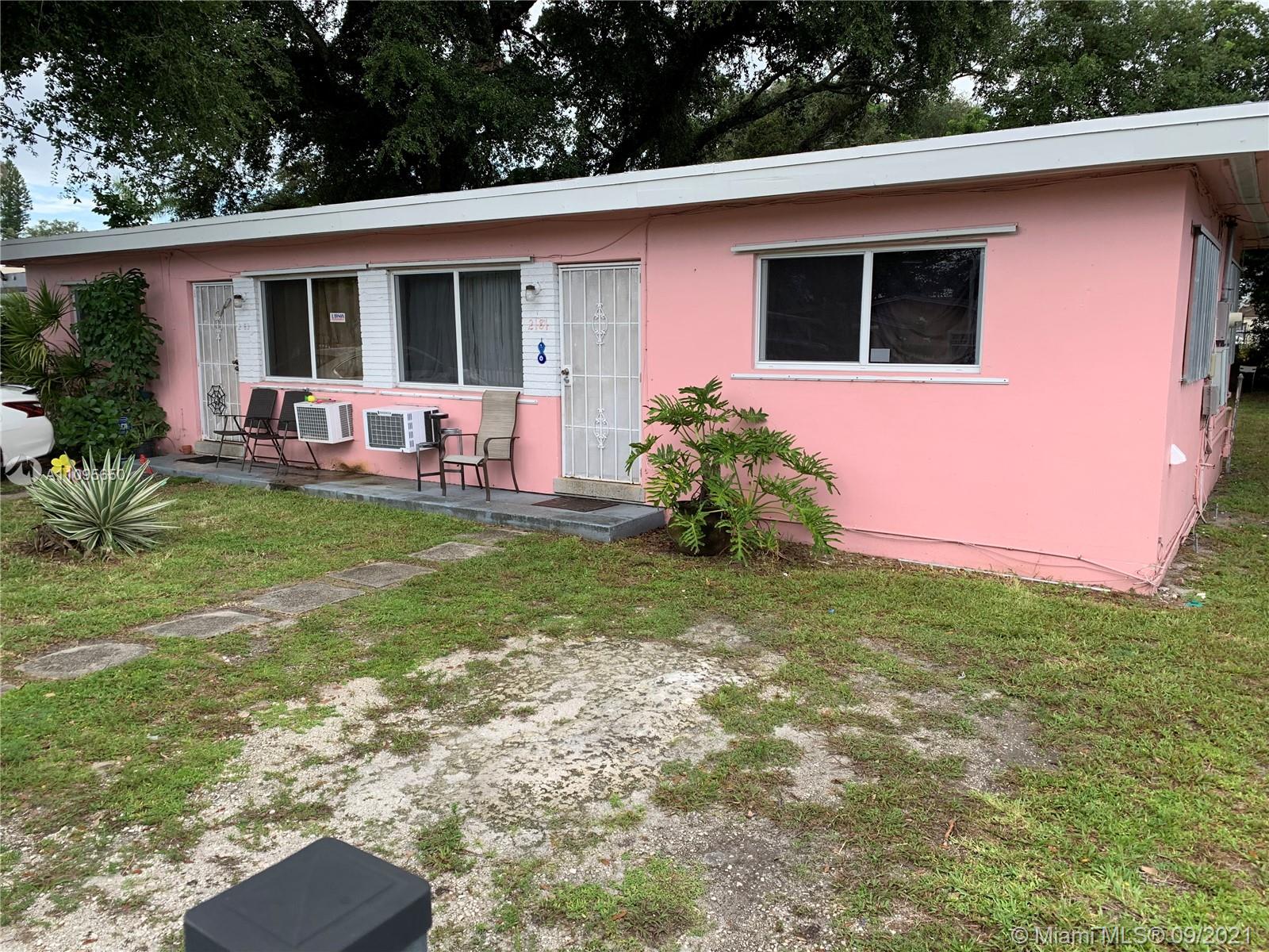 2181 Northwest 91st Street Miami, FL 33147 - Photo 1 of 2 a backyard of a house with table and chairs potted plants and large tree