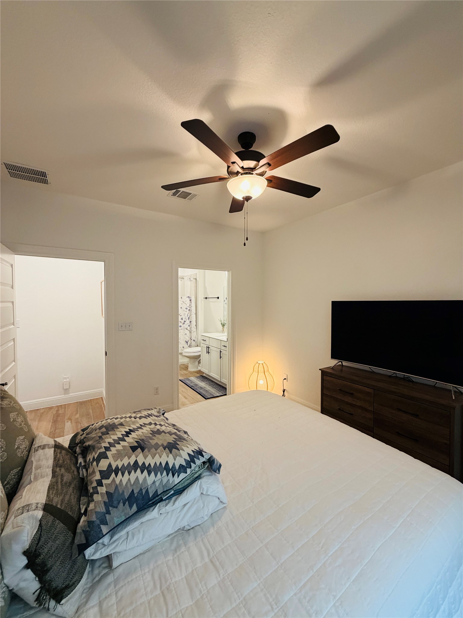 268 Fish Trap Road Dripping Springs, TX 78620 - Photo 17 of 23 A comfortable bedroom layout seamlessly connects to an adjoining private bathroom.