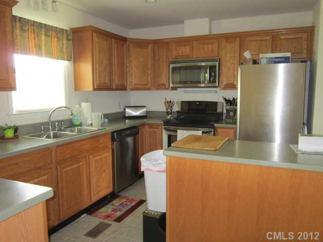 114 Rabbit Highway Harmony, NC 28634 - Photo 6 of 16 a kitchen with stainless steel appliances a refrigerator a sink a stove a microwave and wooden cabinets