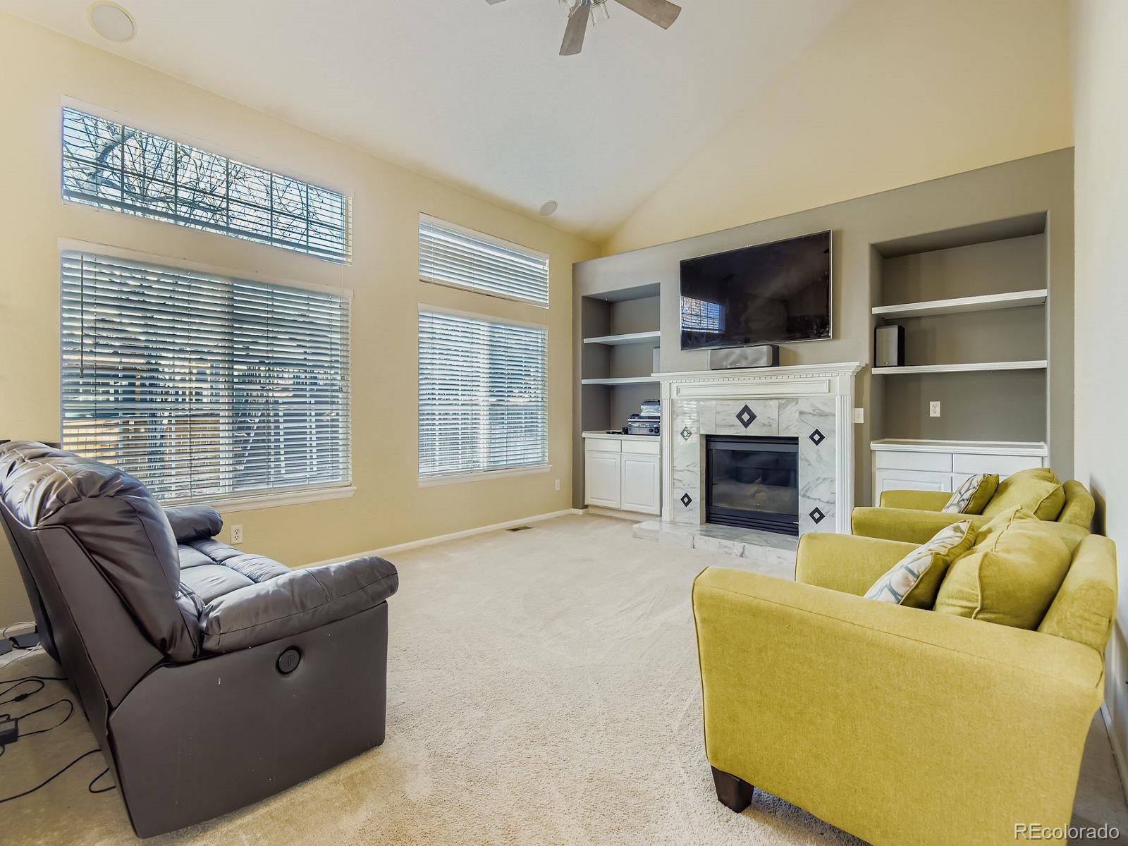 10036 Brisbane Lane Highlands Ranch, CO 80130 - Photo 11 of 27 a living room with furniture flat screen tv and a fireplace