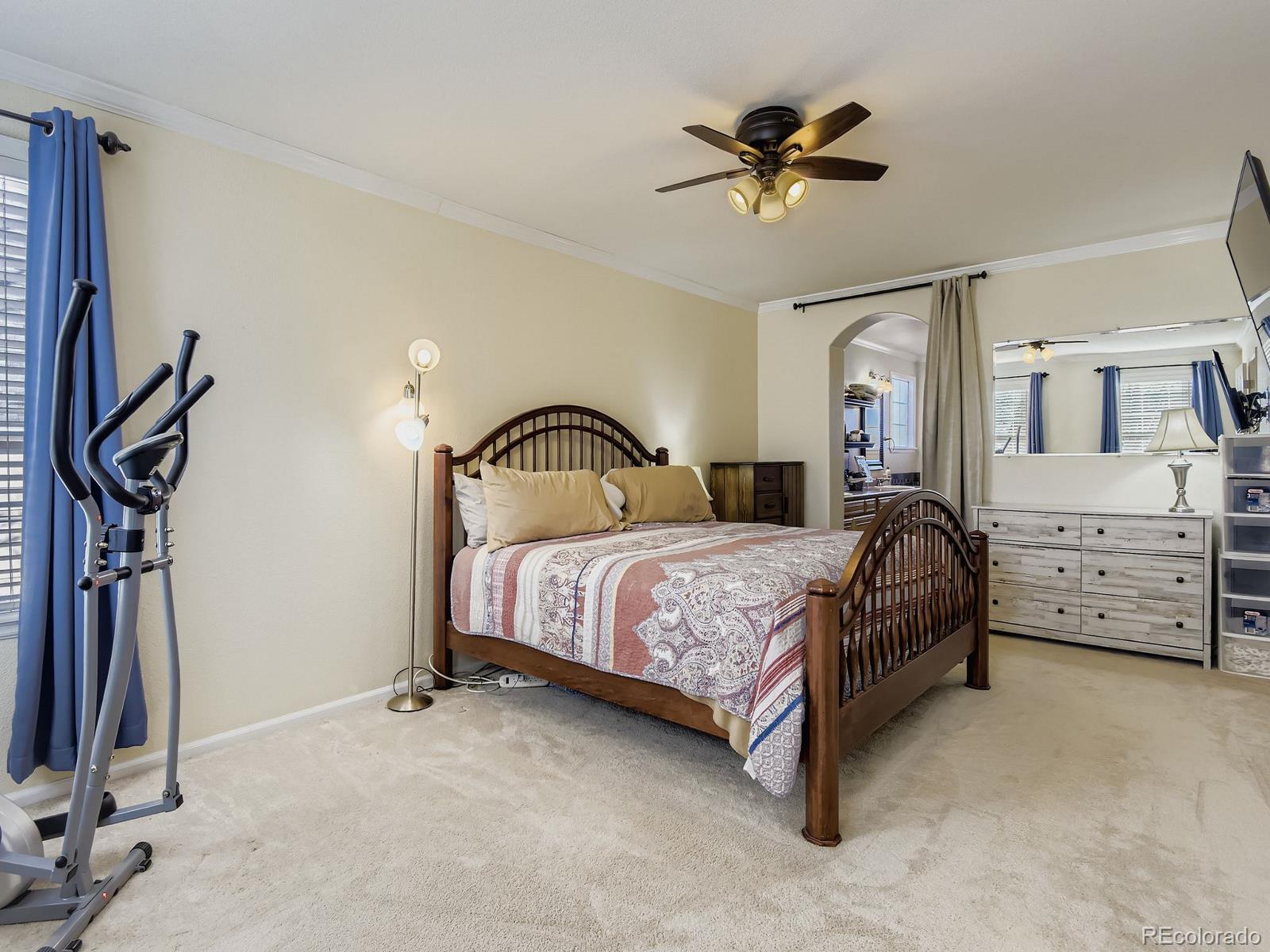 10036 Brisbane Lane Highlands Ranch, CO 80130 - Photo 14 of 27 a bedroom with bed and a chandelier