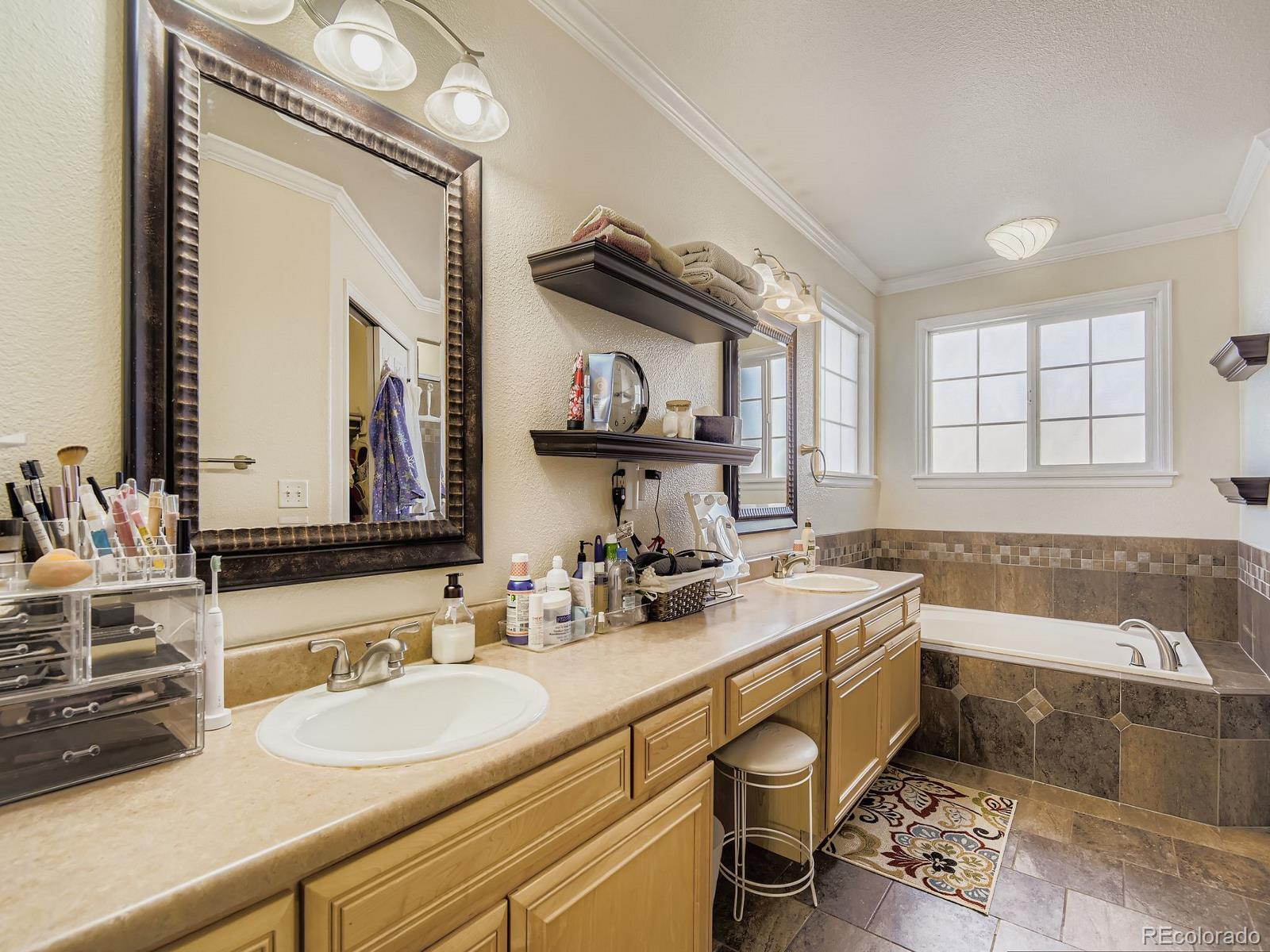 10036 Brisbane Lane Highlands Ranch, CO 80130 - Photo 17 of 27 a bathroom with a sink double vanity and a mirror