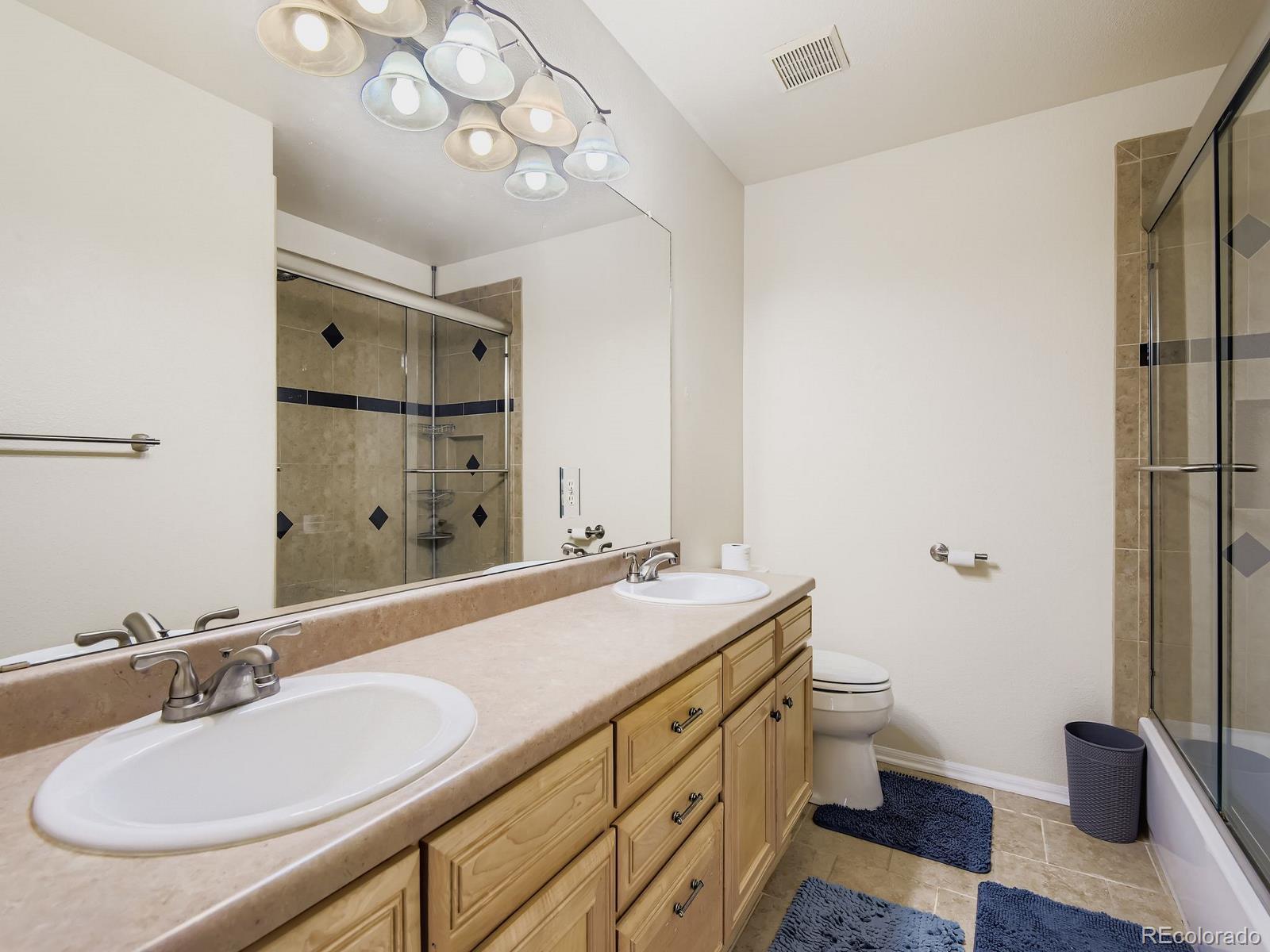 10036 Brisbane Lane Highlands Ranch, CO 80130 - Photo 22 of 27 a bathroom with a granite countertop sink a toilet and a mirror
