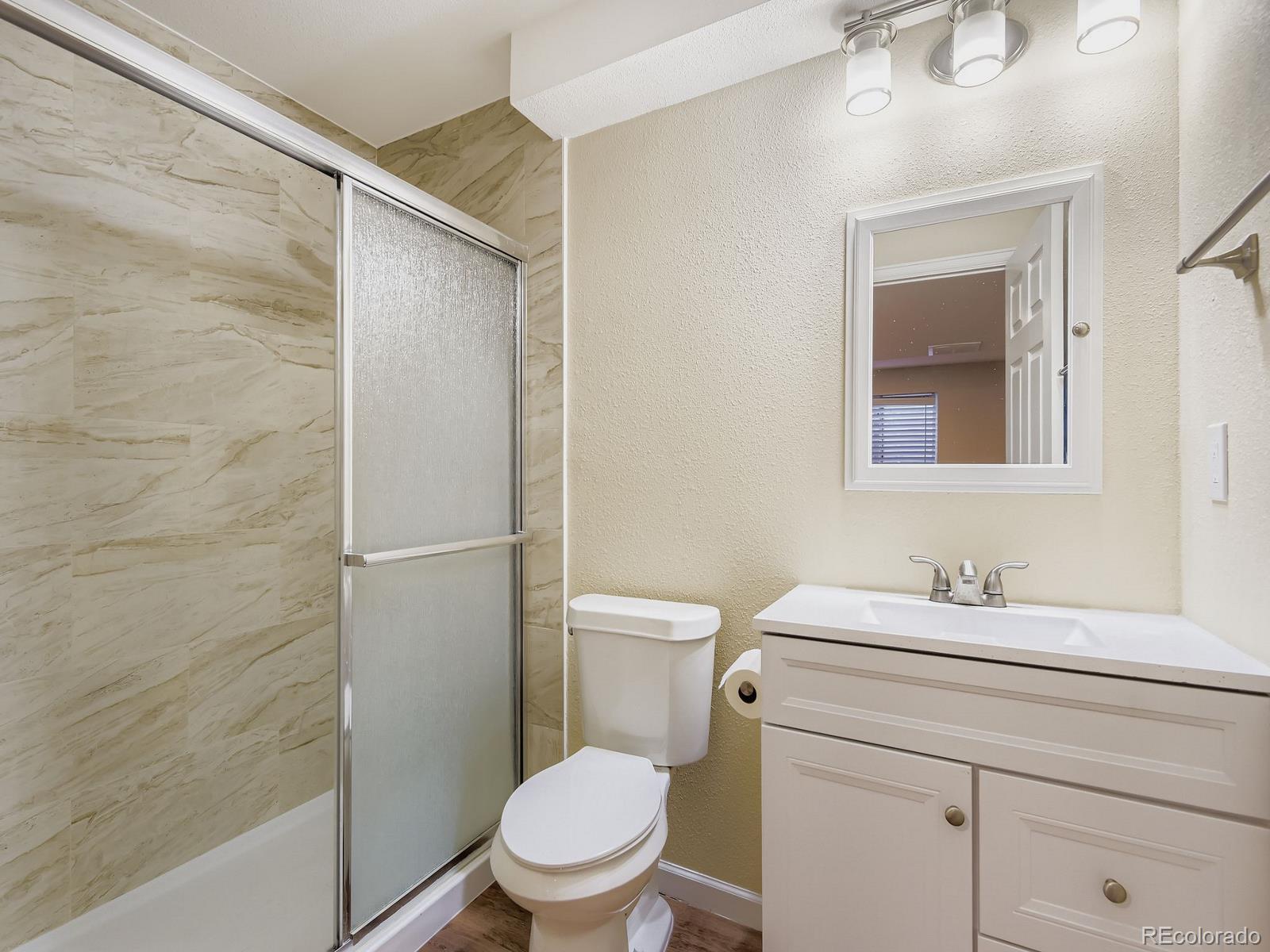 10036 Brisbane Lane Highlands Ranch, CO 80130 - Photo 24 of 27 a bathroom with a toilet sink vanity and shower