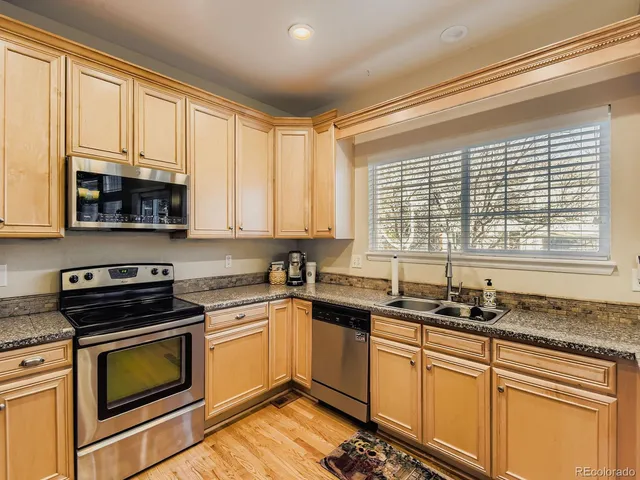 a kitchen with granite countertop a sink window and cabinets