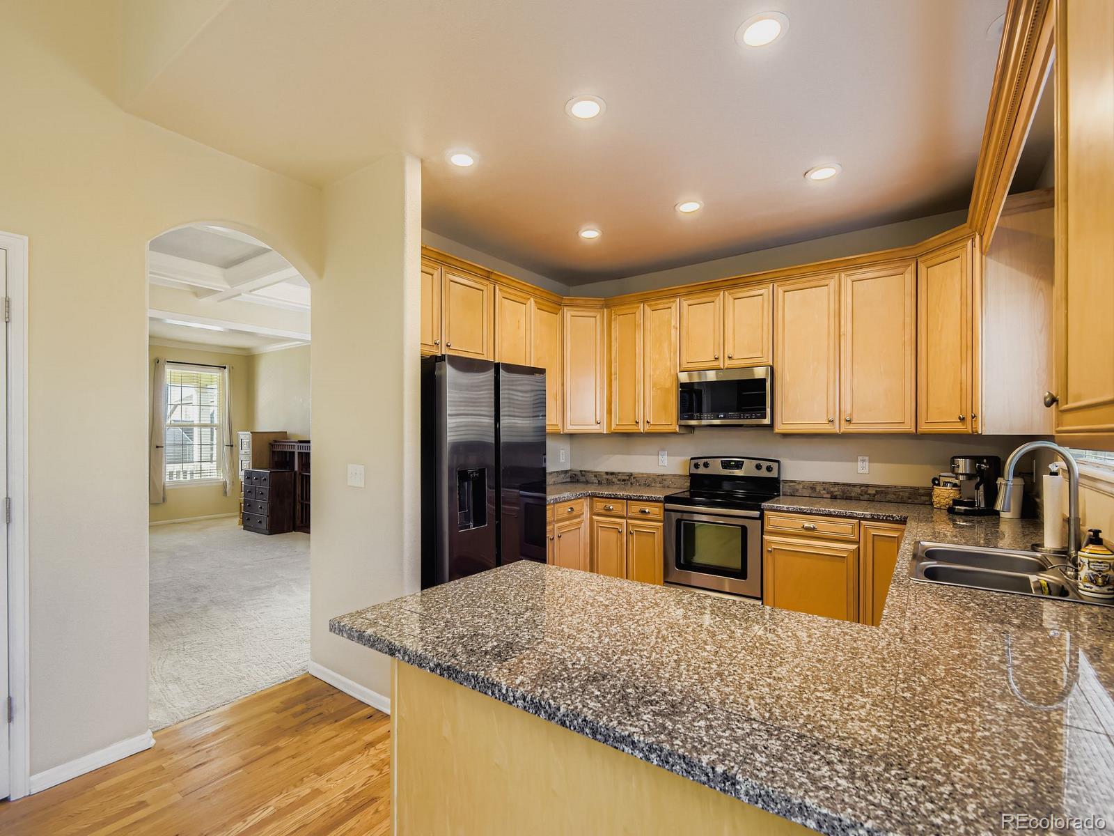 10036 Brisbane Lane Highlands Ranch, CO 80130 - Photo 9 of 27 a kitchen with stainless steel appliances granite countertop a sink stove and refrigerator