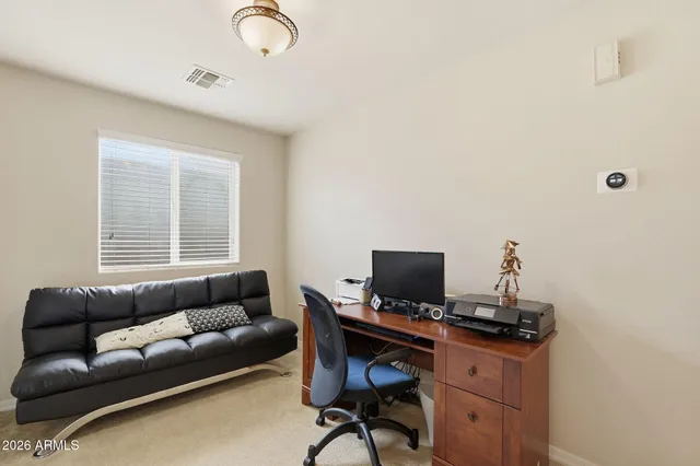 a view of a workspace with furniture and a window