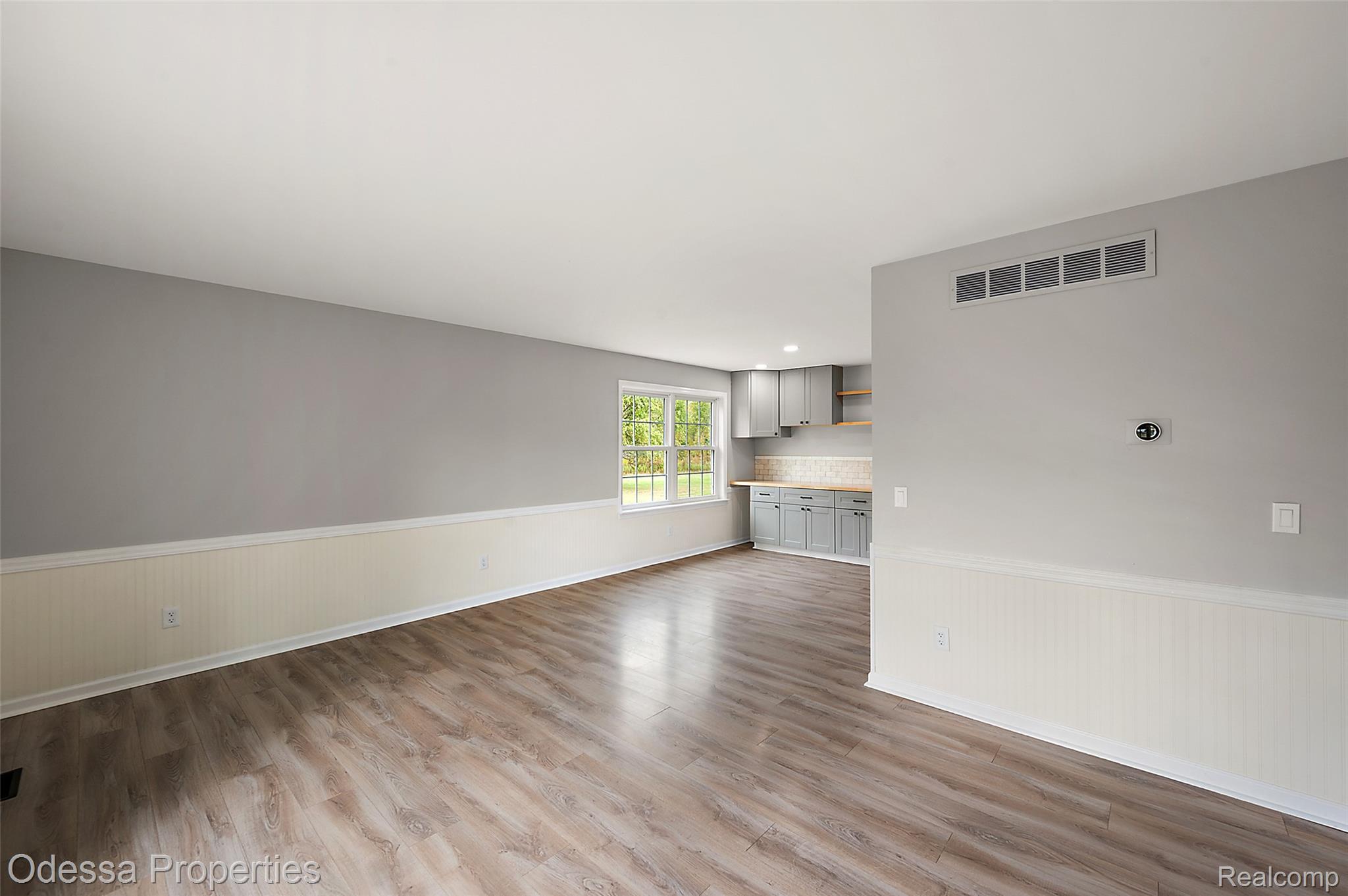 1442 Riley Center Road Memphis, MI 48041 - Photo 18 of 62 Unfurnished living room featuring a wainscoted wall and light wood-type flooring