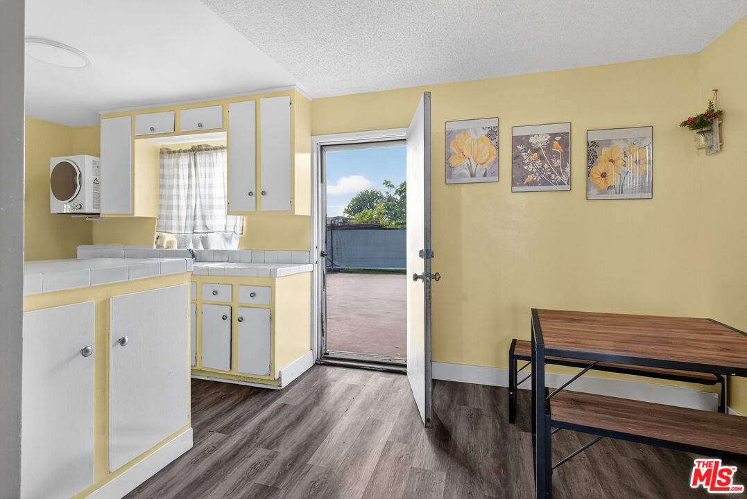 1416 255th Street Harbor City, CA 90710 - Photo 7 of 12 a kitchen with a wooden floor and white walls