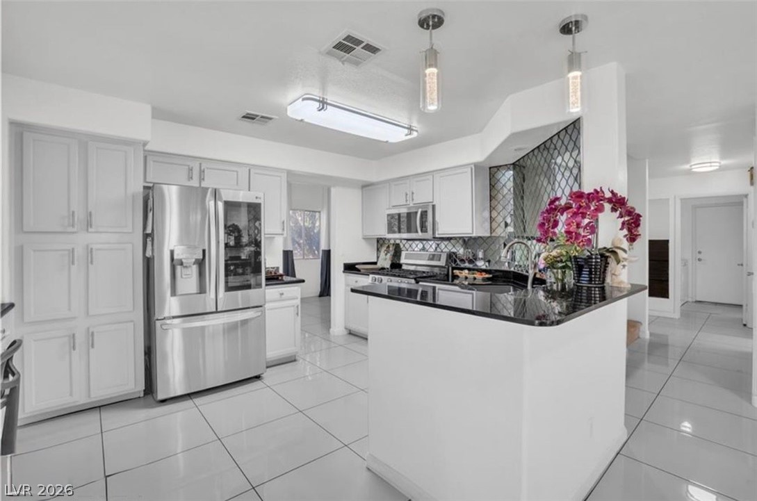 6429 Winding Ridge Las Vegas, NV 89156 - Photo 19 of 22 Culinary aspirations come alive in this kitchen, featuring sleek stainless steel appliances and an inviting island.