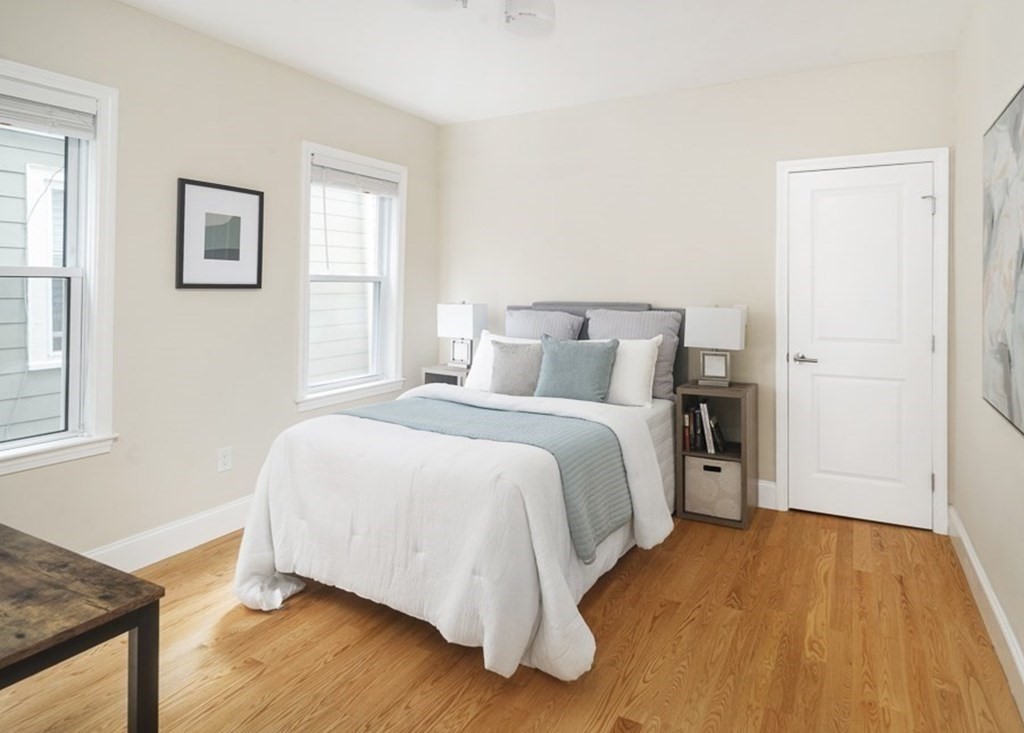 33 Bay State Avenue, Unit 1 Somerville, MA 02144 - Photo 11 of 23 a bedroom with a bed and wooden floor