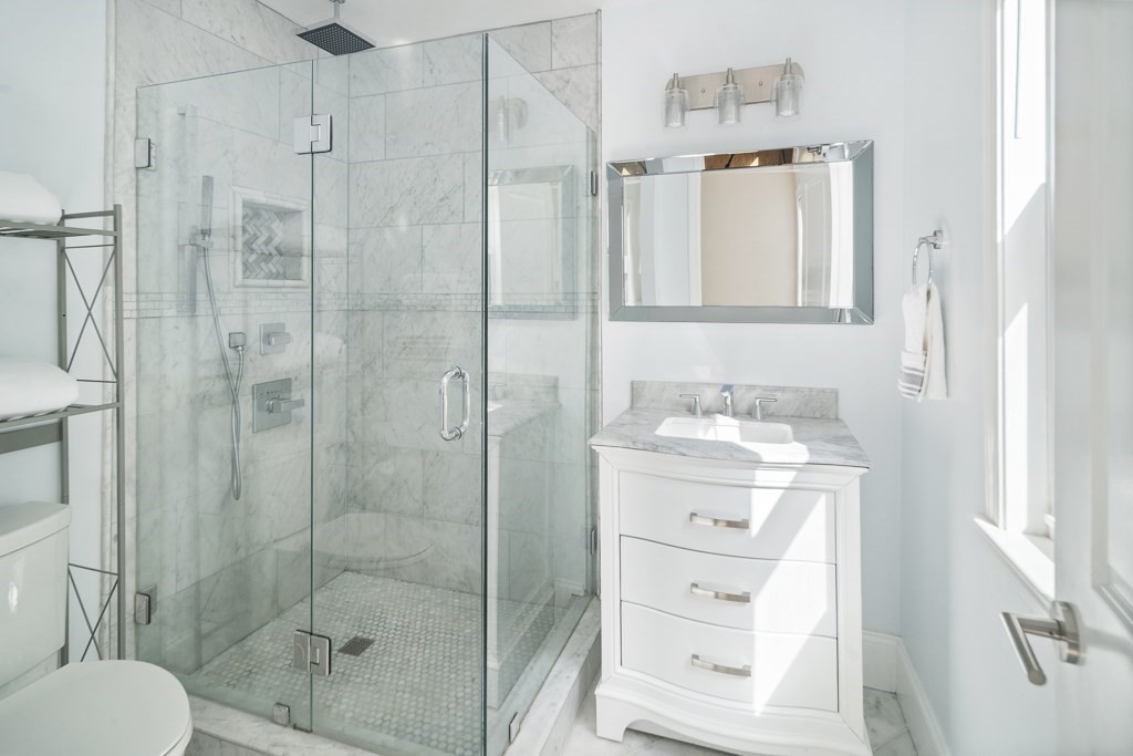 33 Bay State Avenue, Unit 1 Somerville, MA 02144 - Photo 15 of 23 a bathroom with a shower a sink and mirror