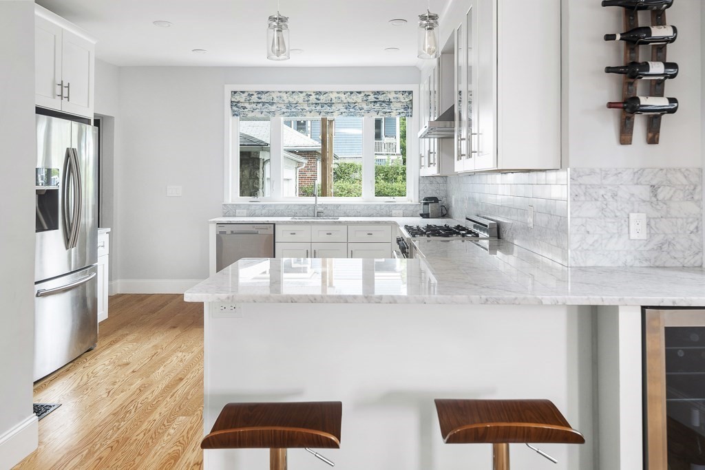 33 Bay State Avenue, Unit 1 Somerville, MA 02144 - Photo 9 of 23 a kitchen with stainless steel appliances granite countertop a sink and a stove