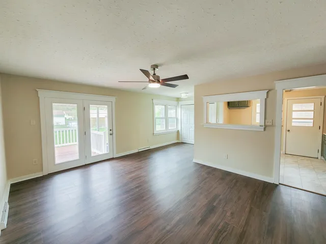 a view of a hallway with wooden floor and staircase