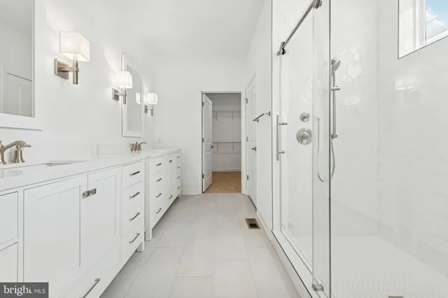 a bathroom with white cabinets and a sink