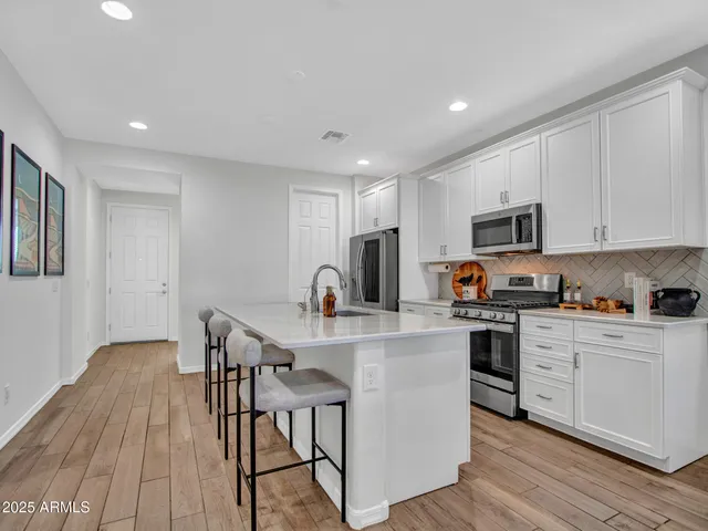 a kitchen with stainless steel appliances granite countertop a stove microwave and refrigerator
