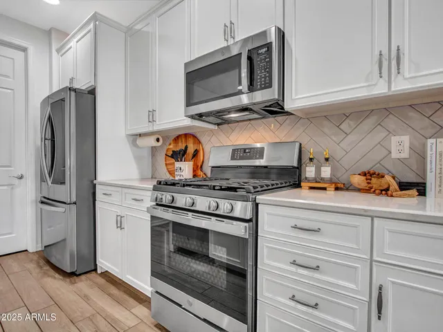 a view of a kitchen with kitchen island a counter top space a sink a stove and wooden floor