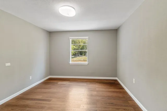 wooden floor in an empty room with a window