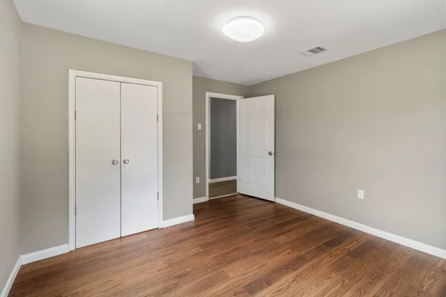 a view of an empty room with wooden floor