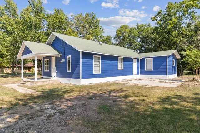 a view of a yard in front of a house with large tree
