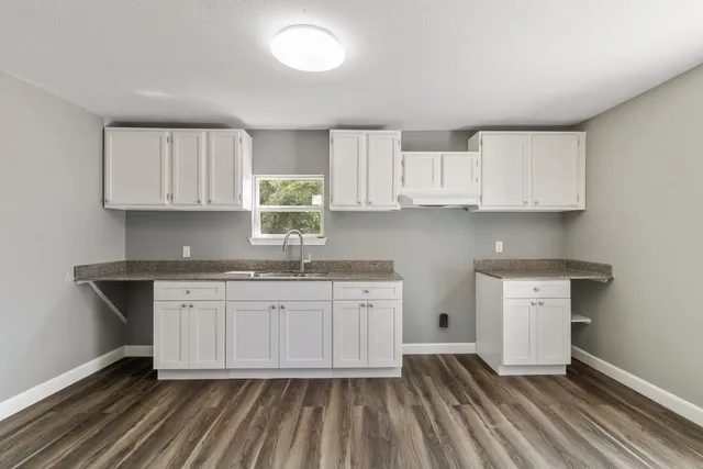 a kitchen with granite countertop white cabinets stainless steel appliances a sink and dishwasher