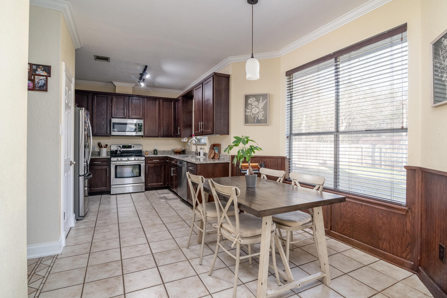 9301 Tea Rose Trail Austin, TX 78748 - Photo 11 of 36 Dining room featuring wood walls, wainscoting, crown molding, and light tile patterned floors