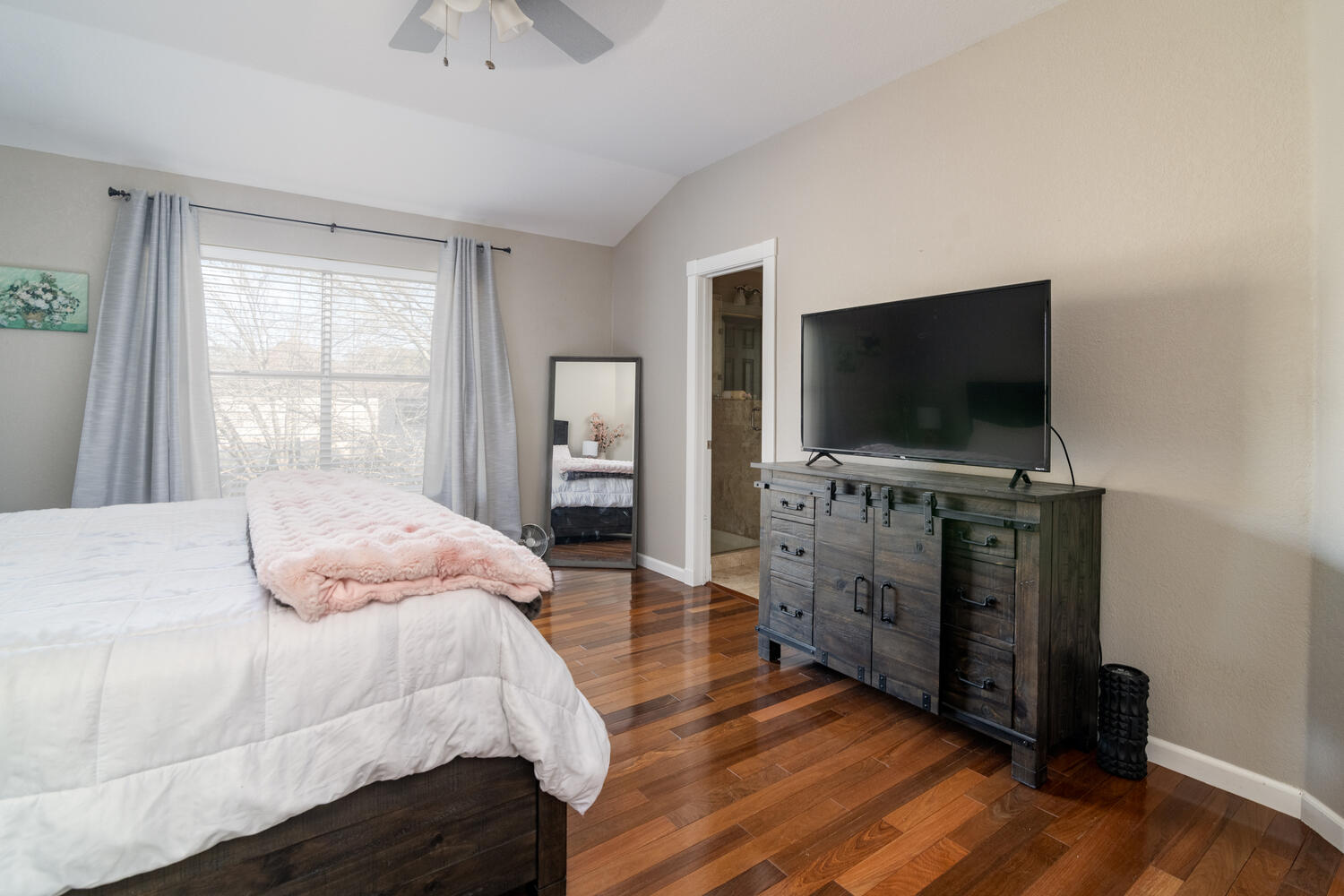 9301 Tea Rose Trail Austin, TX 78748 - Photo 18 of 36 Bedroom featuring dark wood finished floors, connected bathroom, lofted ceiling, and a ceiling fan
