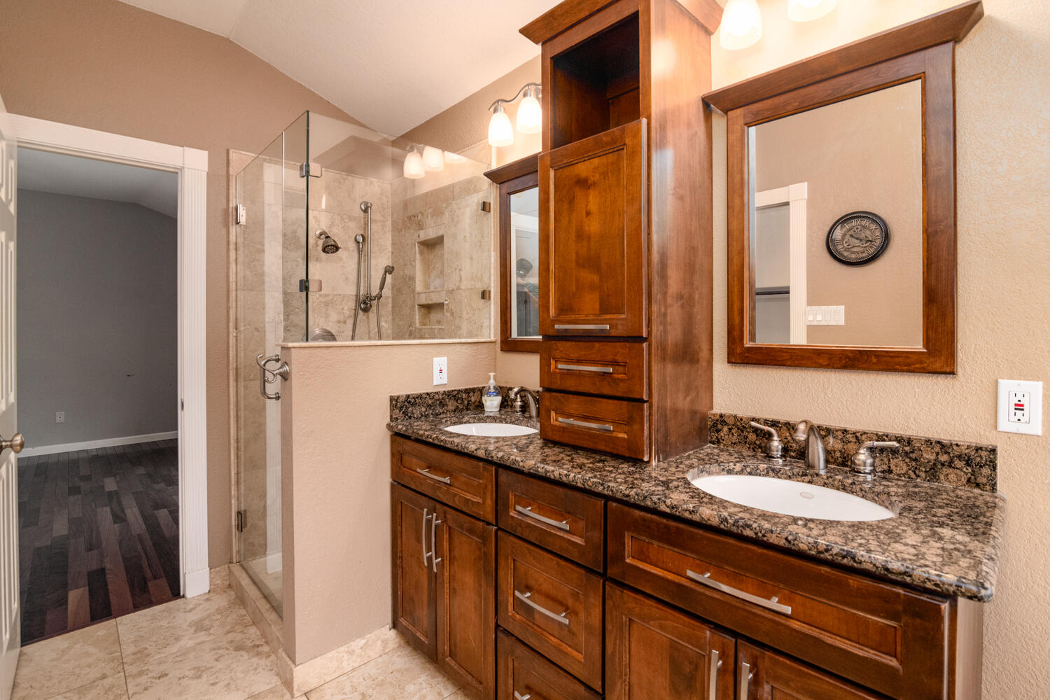 9301 Tea Rose Trail Austin, TX 78748 - Photo 21 of 36 Full bath with double vanity, vaulted ceiling, a shower stall, and light tile patterned floors