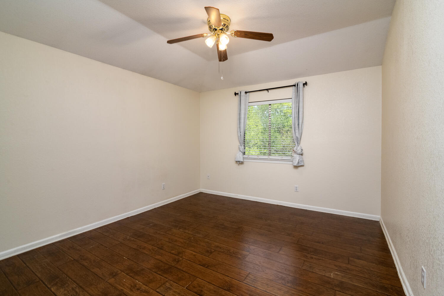 9301 Tea Rose Trail Austin, TX 78748 - Photo 27 of 36 Unfurnished room featuring dark wood-style flooring, vaulted ceiling, and a ceiling fan