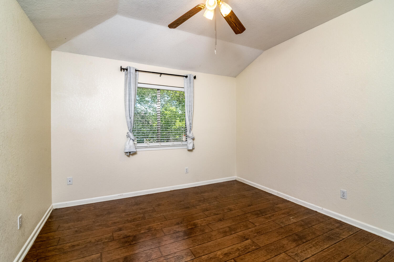 9301 Tea Rose Trail Austin, TX 78748 - Photo 28 of 36 Unfurnished room featuring a ceiling fan, dark wood finished floors, vaulted ceiling, and a textured wall