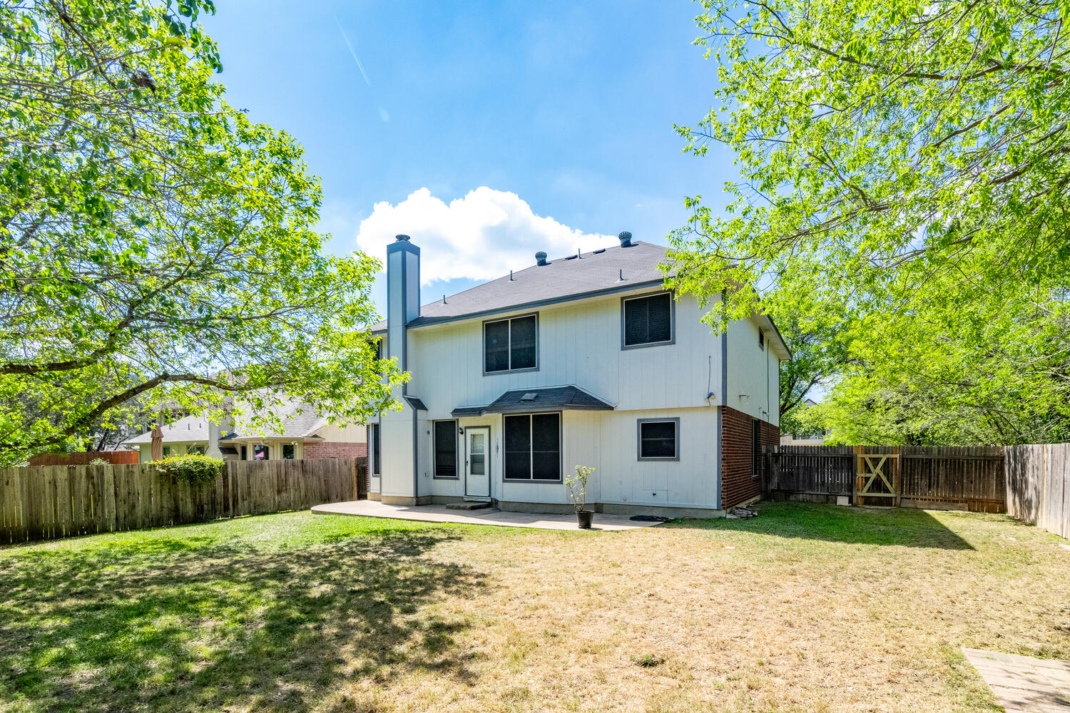 9301 Tea Rose Trail Austin, TX 78748 - Photo 32 of 36 Rear view of property featuring a patio, a chimney, a fenced backyard, and brick siding