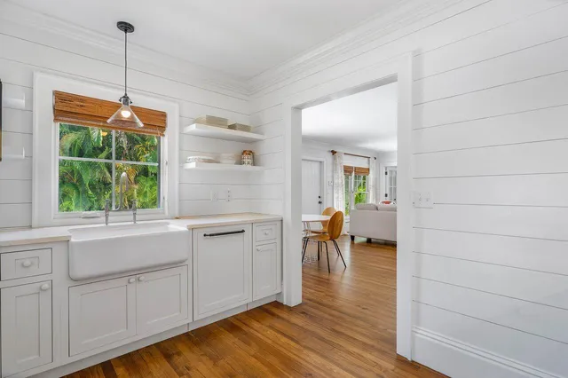 a hallway with white cabinets and wooden floor