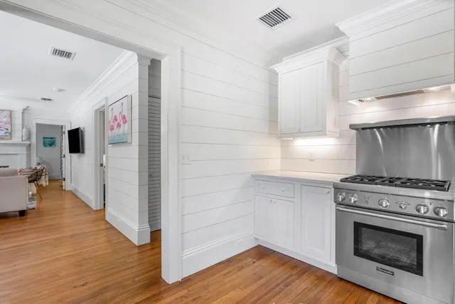 a kitchen with a stove and wooden floor