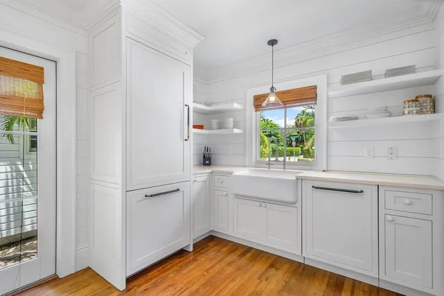 a kitchen with white cabinets and window