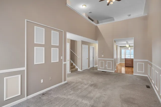 a view of an empty room with furniture and windows