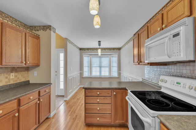 a kitchen with granite countertop a cabinets and a stove top oven