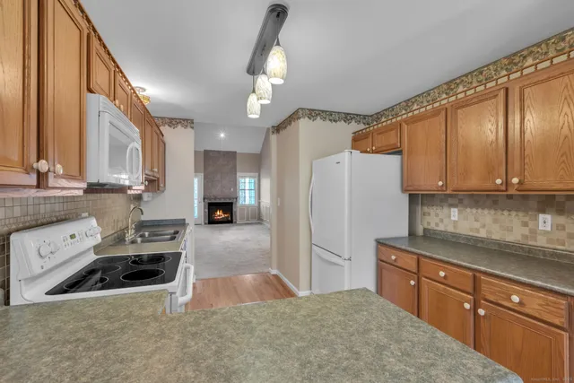 a kitchen with stainless steel appliances granite countertop a refrigerator a stove and a sink