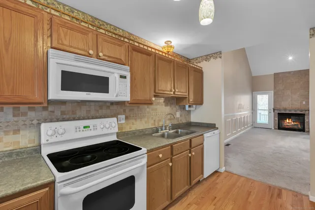 a kitchen with stainless steel appliances a stove a microwave a sink and cabinets