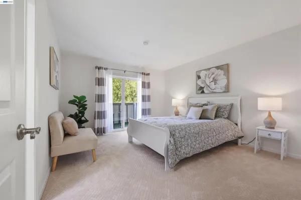 a spacious bedroom with a bed a couch and potted plant on the dresser
