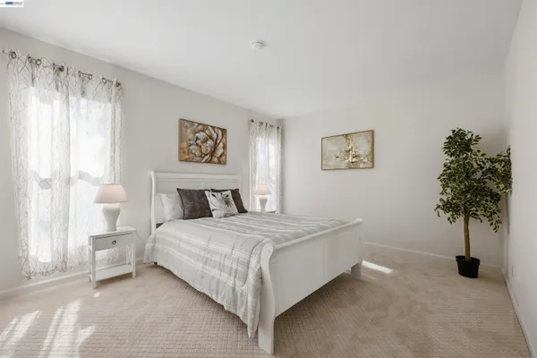 a bedroom with a bed and a potted plant