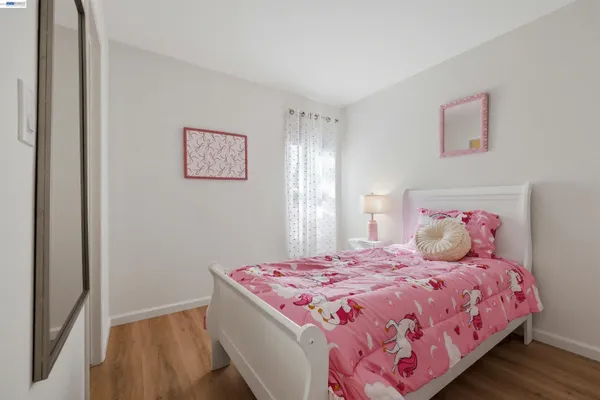 a bedroom with a large bed and wooden floor