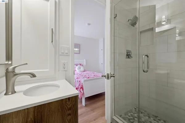 a bathroom with a sink shower and a mirror