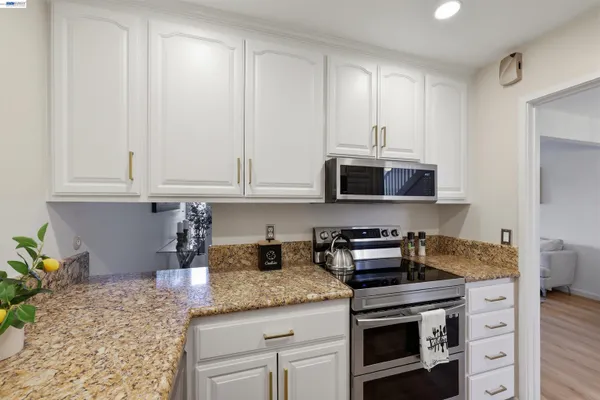 a kitchen with stainless steel appliances granite countertop a stove a microwave and cabinets